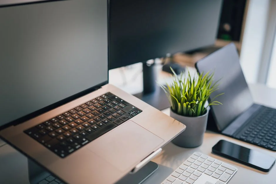 Man working on web design at home office setup with dual monitors.